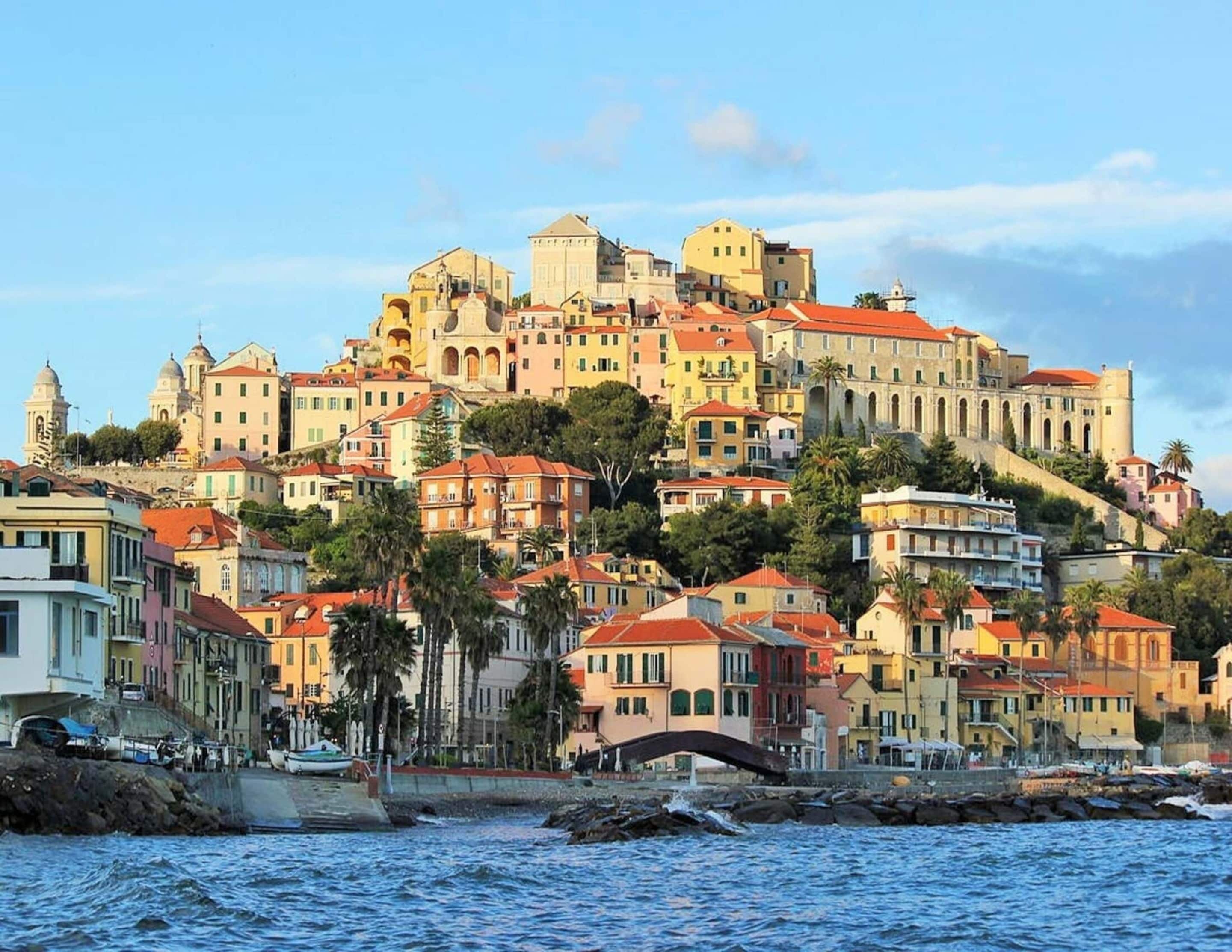A coastal town with historic buildings, a prominent castle, and a bridge connecting to the waterfront.