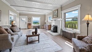 Un salón amplio con techo alto, ventanas grandes y chimenea.