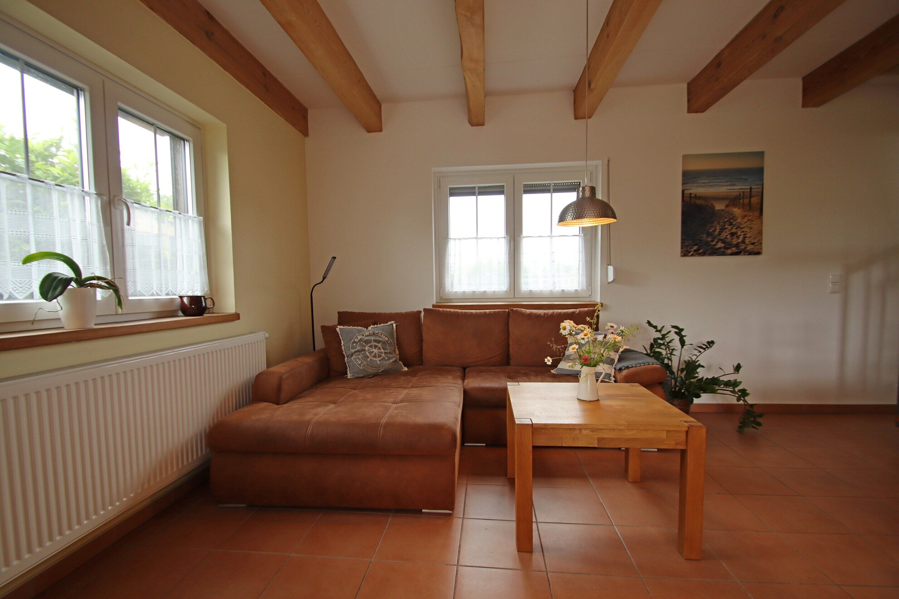 Ein Wohnzimmer mit braunem Sofa, einem Holztisch und einem Bild an der Wand.