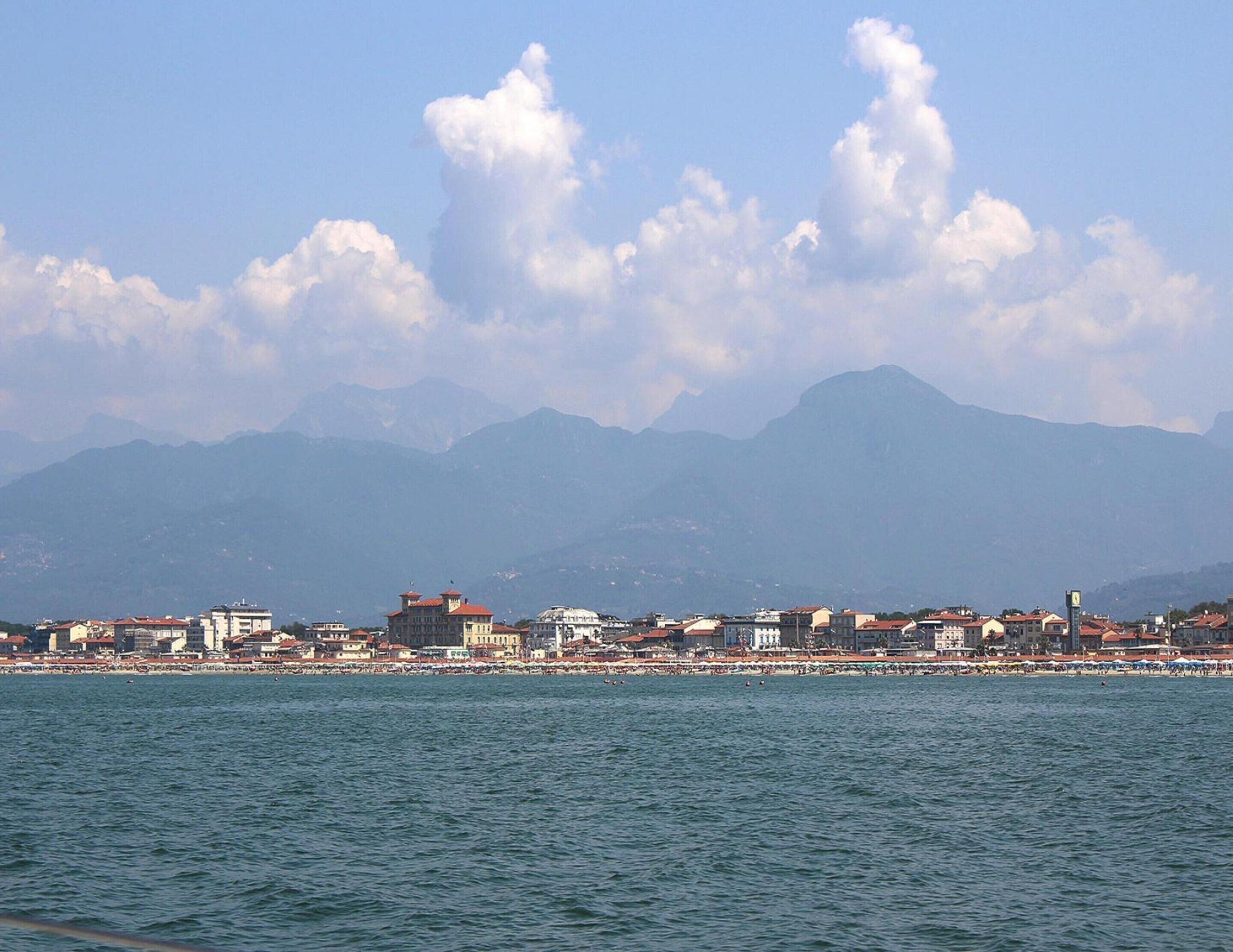 A coastal cityscape with a view of mountains in the background.