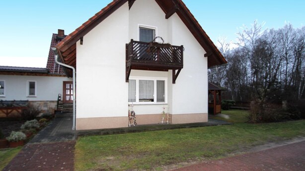 A two-story house with a balcony, a small porch, and a brick pathway leading to the entrance. - Ferienwohnungen Spreewaldperle, Alt Zauche (Alt Zauche-Wußwerk)