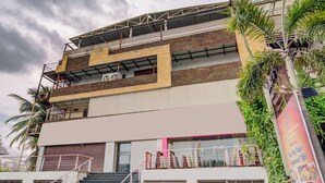 Un immeuble à plusieurs étages doté d’une architecture moderne, caractérisé par un mélange de briques et de béton, et un escalier imposant menant aux niveaux supérieurs.