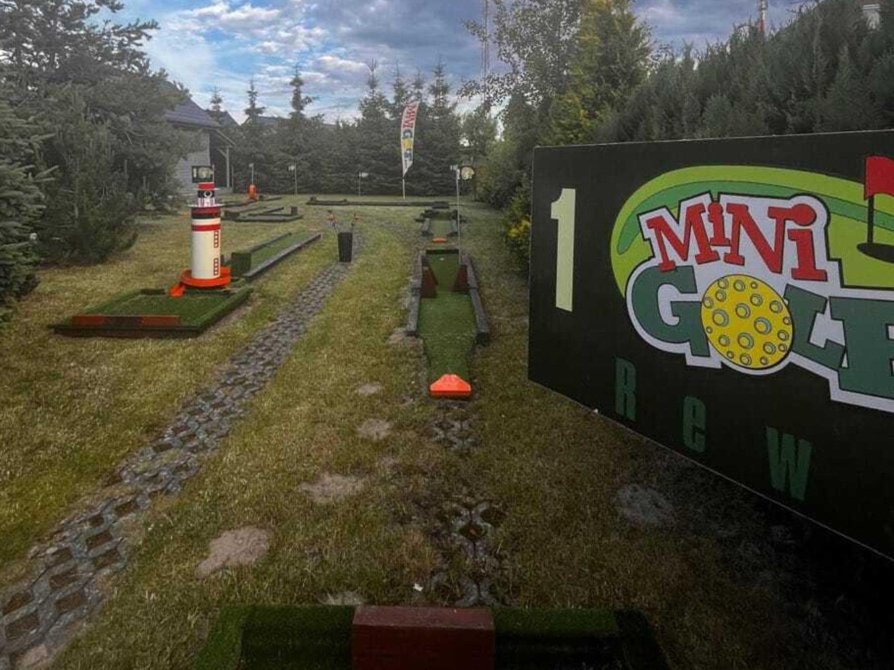 En minigolfbana med en skylt som visar texten: ”1 MINI GOLF REW”.