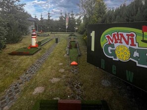 Un parcours de mini-golf avec un panneau indiquant : « 1 MINI-GOLF ».