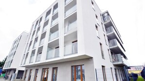 En modern byggnad med flera våningar, balkonger och stora fönster.
