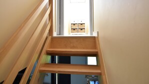 A wooden staircase leading to a room with a window and a door. - Cottage in a Quiet Location, Slajszewo (Choczewo)