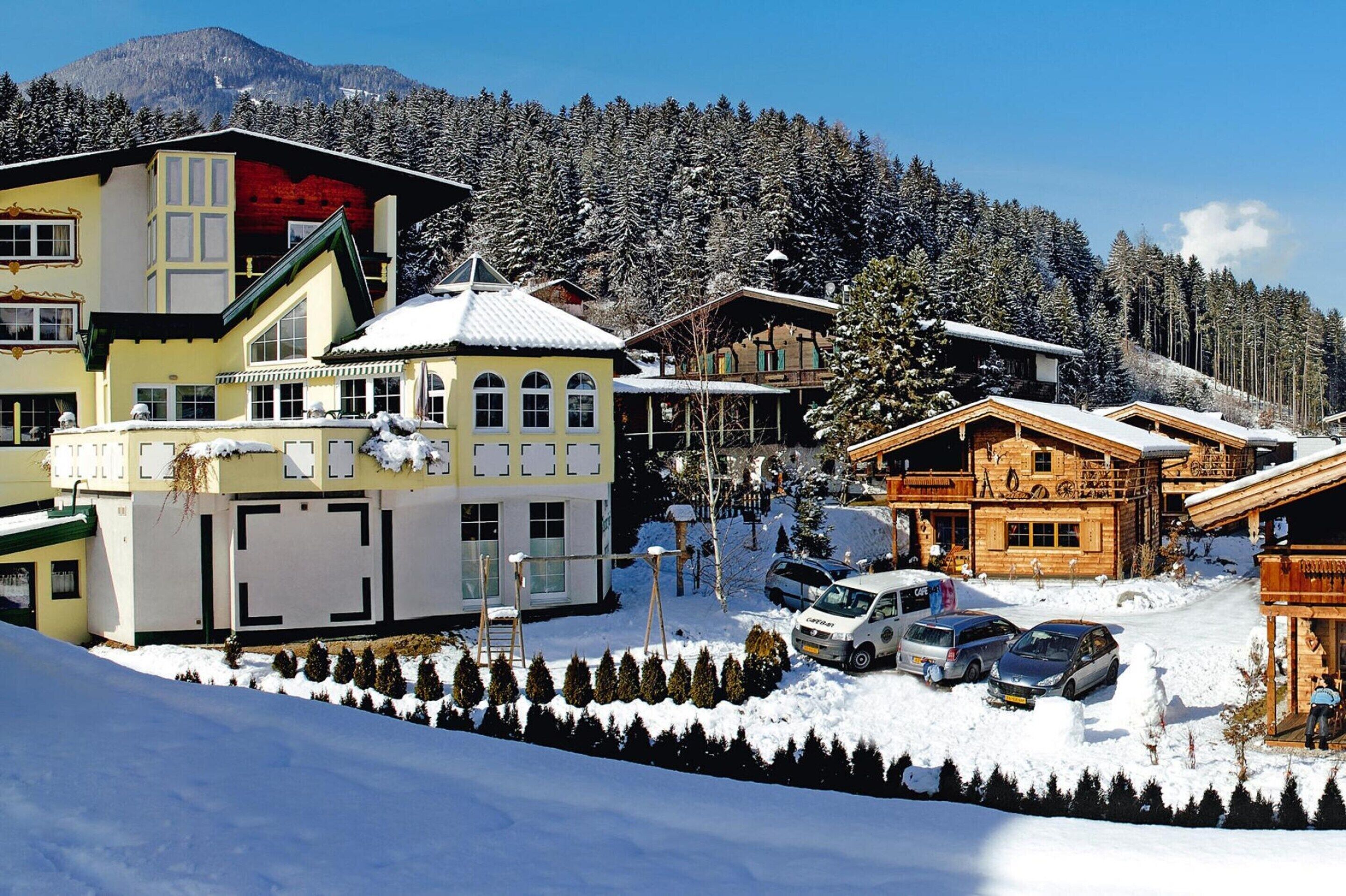 A snow-covered mountain village with wooden buildings and a clear sky.