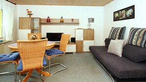 A compact living space with a dining area, a sofa, and a kitchenette. - Ferienhaus, Plau am See (Plau am See)