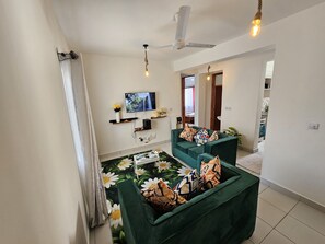 Appartement familial, balcon, vue sur la ville | Aire de séjour | Téléviseur connecté de 24 po avec télévision numérique