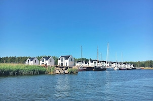 A marina with several white houses and boats docked along the water's edge.