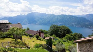 A residential area with houses, a grassy yard, and a lake with mountains in the background. - Casa Monti Neues Modernes Haus in den Bergen von Monti di Vairano (Monti di Vairano)