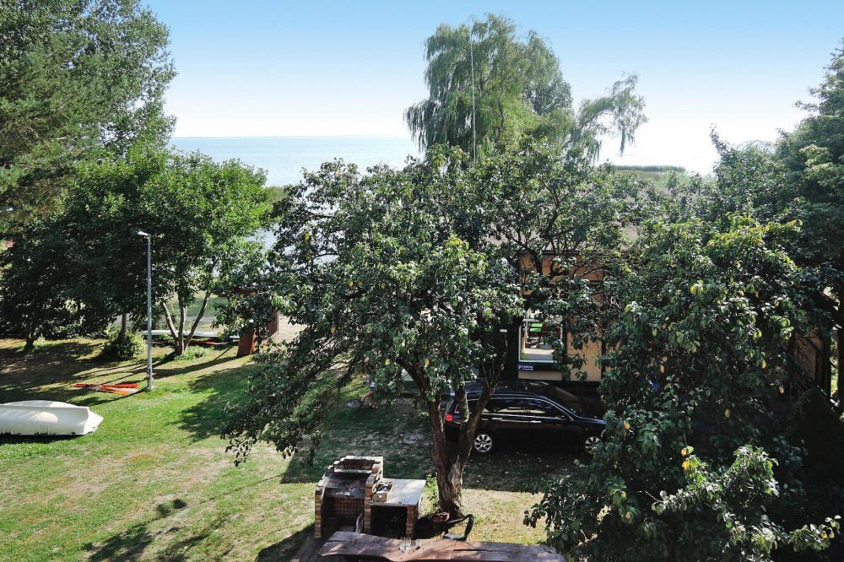 A backyard with a barbecue grill, a car, and a boat.
