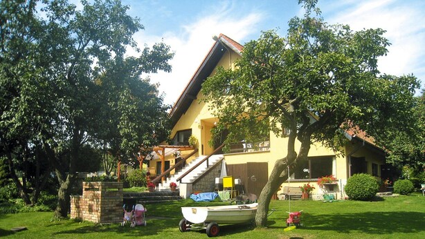 A house with a sloped roof, a visible staircase, and a boat in the yard. - Holiday Home in Sulomino With Private Beach (gmina Wolin)