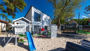 Une aire de jeux avec un toboggan, un mur d’escalade et des balançoires.