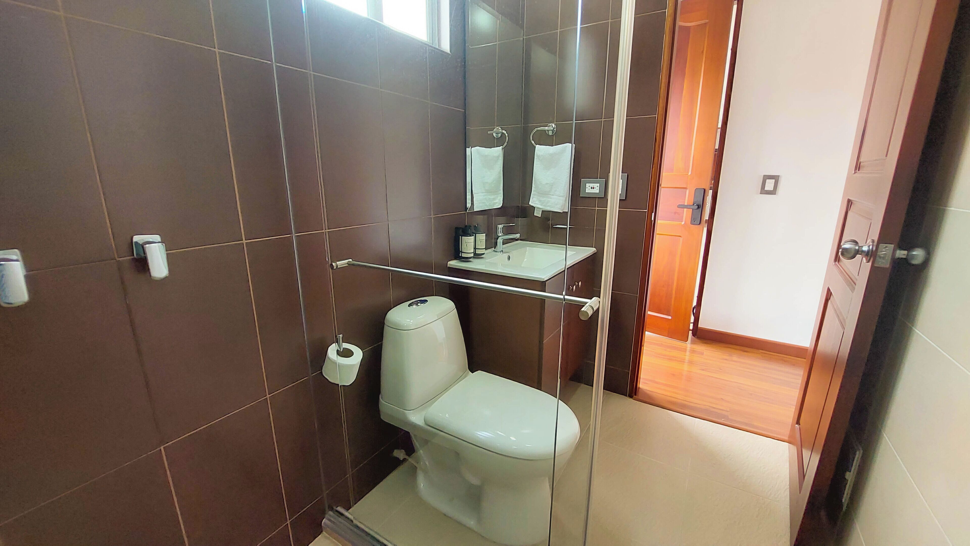 A bathroom with a toilet, a sink, and a mirror.
