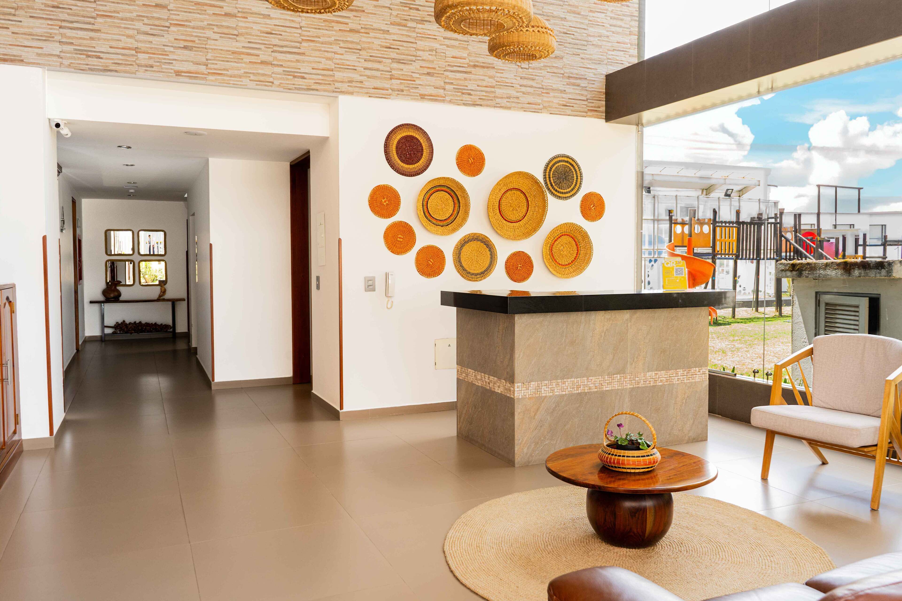 Un intérieur moderne avec un îlot central, un coin salon et un mur orné de motifs circulaires.