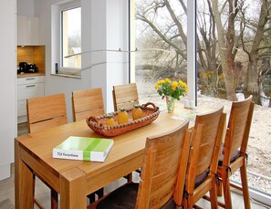 Enjoy meals in this dining area with a table for six, a wicker fruit basket, and a vase with flowers.