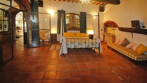 Une chambre à coucher avec un lit à baldaquin, un canapé, une cheminée et un lustre.