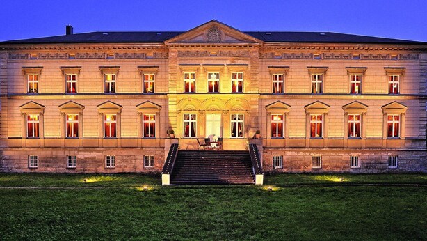 A large, symmetrical building with a central entrance, multiple windows, and a staircase leading up to the entrance. - Schlossurlaub Nahe Ostsee und Tressower See (Bobitz)