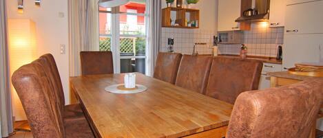 A dining area with a wooden table and brown leather chairs.