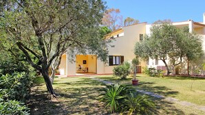 Una casa moderna con un patio, rodeada de árboles y un césped bien cuidado.