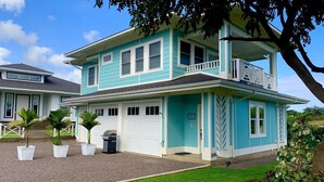 A two-story house with a garage, a balcony, and a well-maintained lawn. - koolkondo 2606 Halalu Guest house (Koloa)