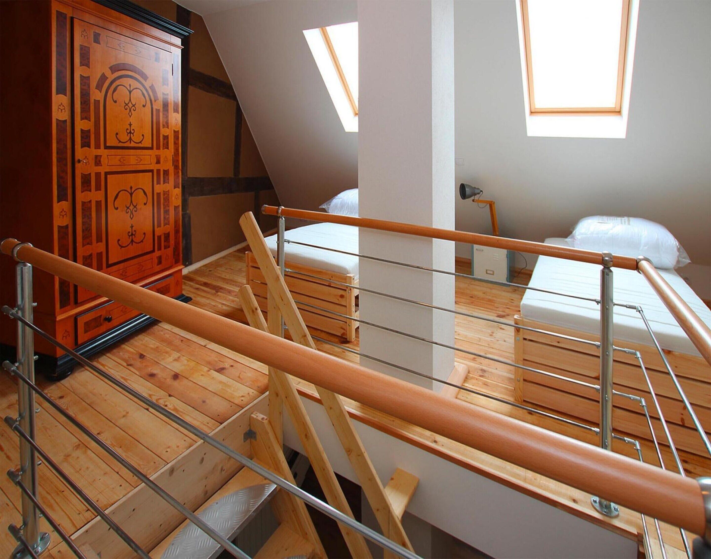 A room with a loft bed, a wooden wardrobe, and skylights.