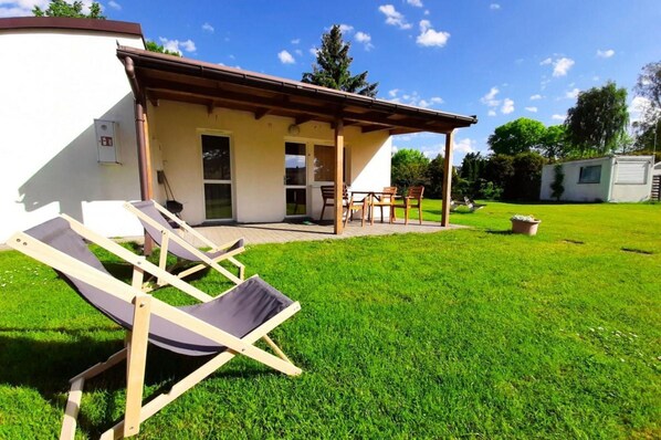 A house with a patio, a lawn, and a small shed. - Cottage With a Terrace for 2 People, Kolobrzeg (Kolobrzeg)