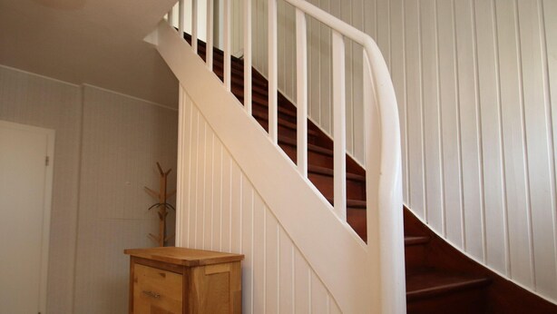A staircase with white railings and wooden steps. - Doppelhaushalfte in Dornumersiel (Dornum)