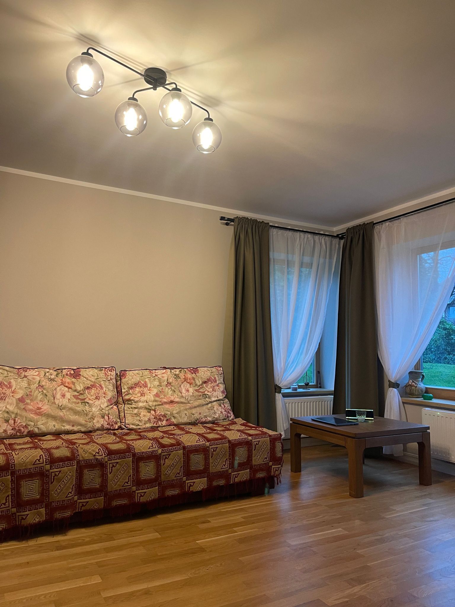 Un soggiorno con divano, tavolo e lampadario.