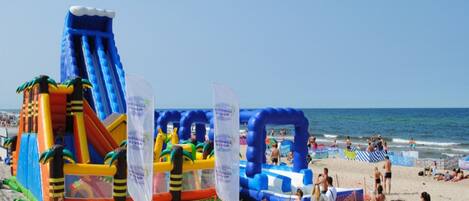 Un parque acuático inflable con toboganes y estructuras de juego en la playa.