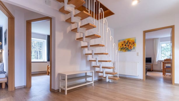 A spacious room with a wooden staircase, a bench, and a painting on the wall. - Tolle Ferienwohnung in St.peter Ording (St. Peter-Ording)