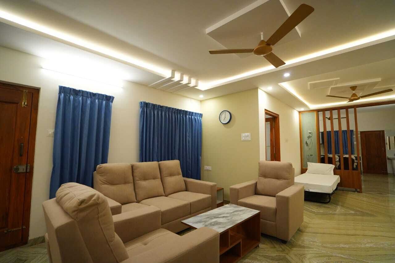 Un salon avec des canapés de couleur beige, une table basse et un ventilateur de plafond.