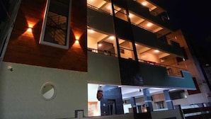 Un immeuble à plusieurs étages doté de balcons et d’un éclairage extérieur.