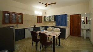 Une cuisine compacte avec un coin repas, un ventilateur de plafond et un évier.