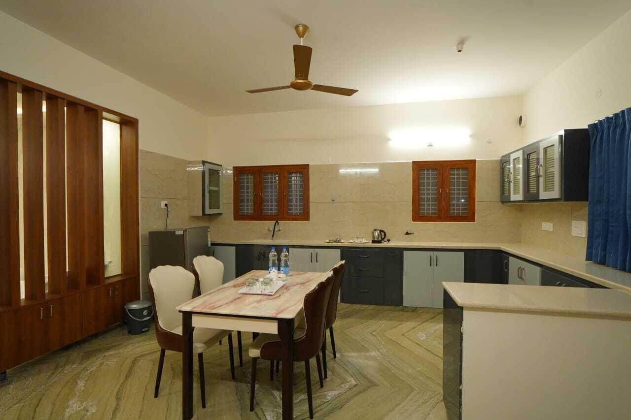 A compact kitchen with a dining area, a ceiling fan, and cabinets with glass doors.