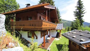 A wooden chalet with a balcony, a covered deck, and a view of the surrounding mountains. - Chalet in Konigsleiten Near Ski Slopes (Wald im Pinzgau)