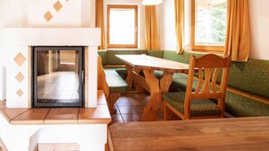 Ein gemütliches Zimmer mit Kamin, Holzmöbeln und großen Fenstern.