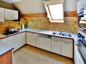 A kitchen with a built-in oven, a sink, and a window above the countertop. - Cottage by Ostrowieckie Lake With Private Beach (Malechowo)
