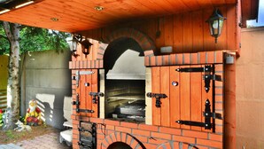 A brick oven with a chimney, a wooden door, and a metal latch. - Cottage by Ostrowieckie Lake With Private Beach (Malechowo)
