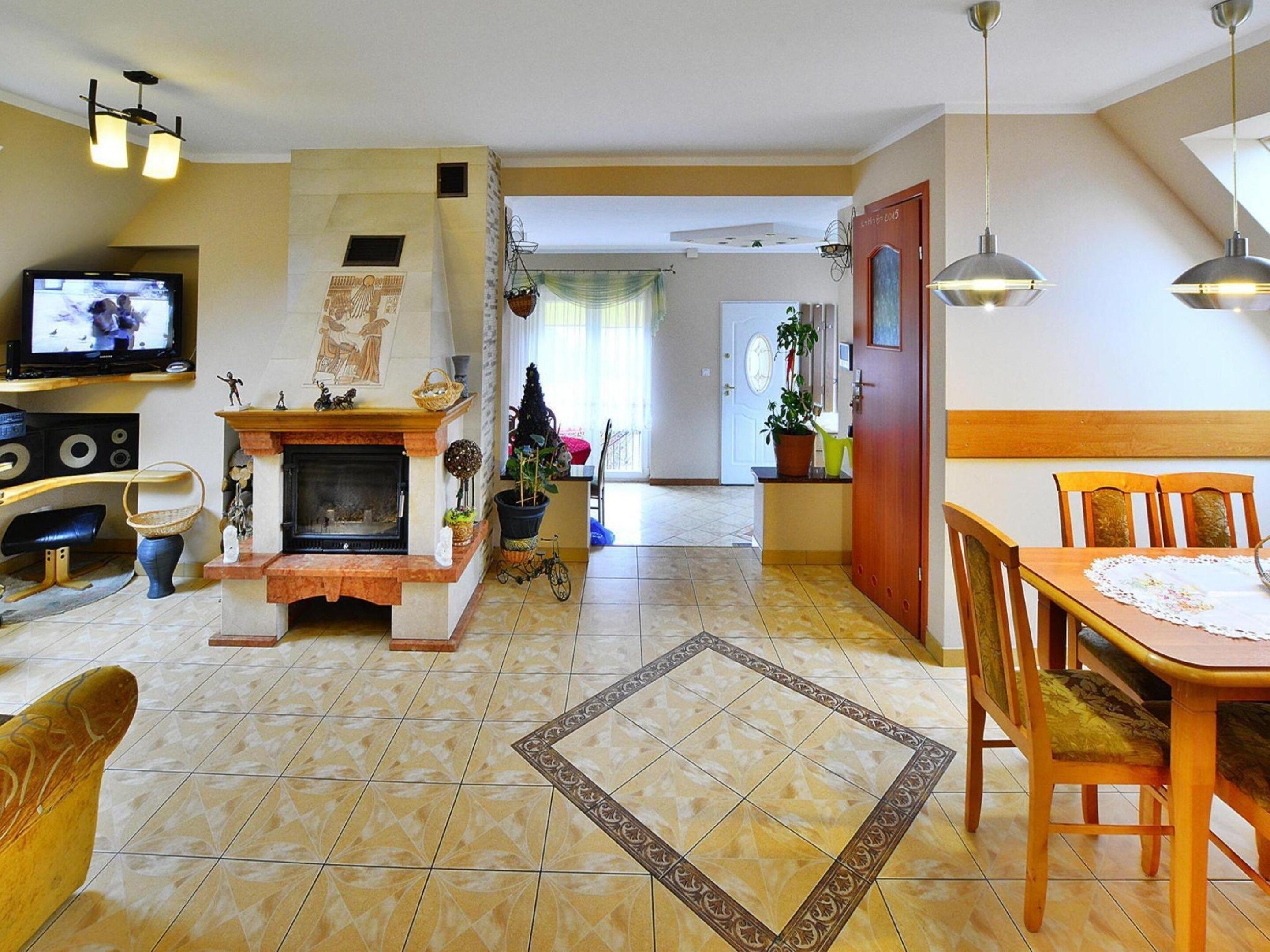 A living room with a fireplace, television, and dining area.