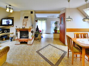 Ein Wohnzimmer mit Kamin, Fernseher und Essbereich.