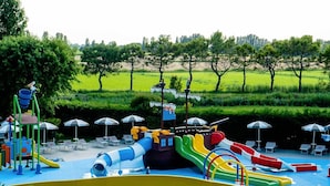 Un parc aquatique doté de nombreux toboggans et d’une grande piscine jaune.