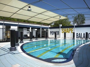 A swimming pool with a covered area, a fitness center, and a wall with motivational words. - Bungalow in Caorle With Garden Furniture (Caorle)
