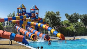 Un parc aquatique doté d’un grand toboggan et d’un espace piscine.