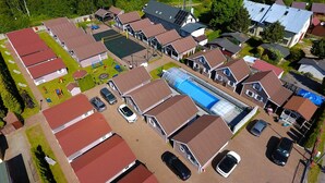 Vista aérea de una zona residencial con varias casas, una piscina y un parque infantil.