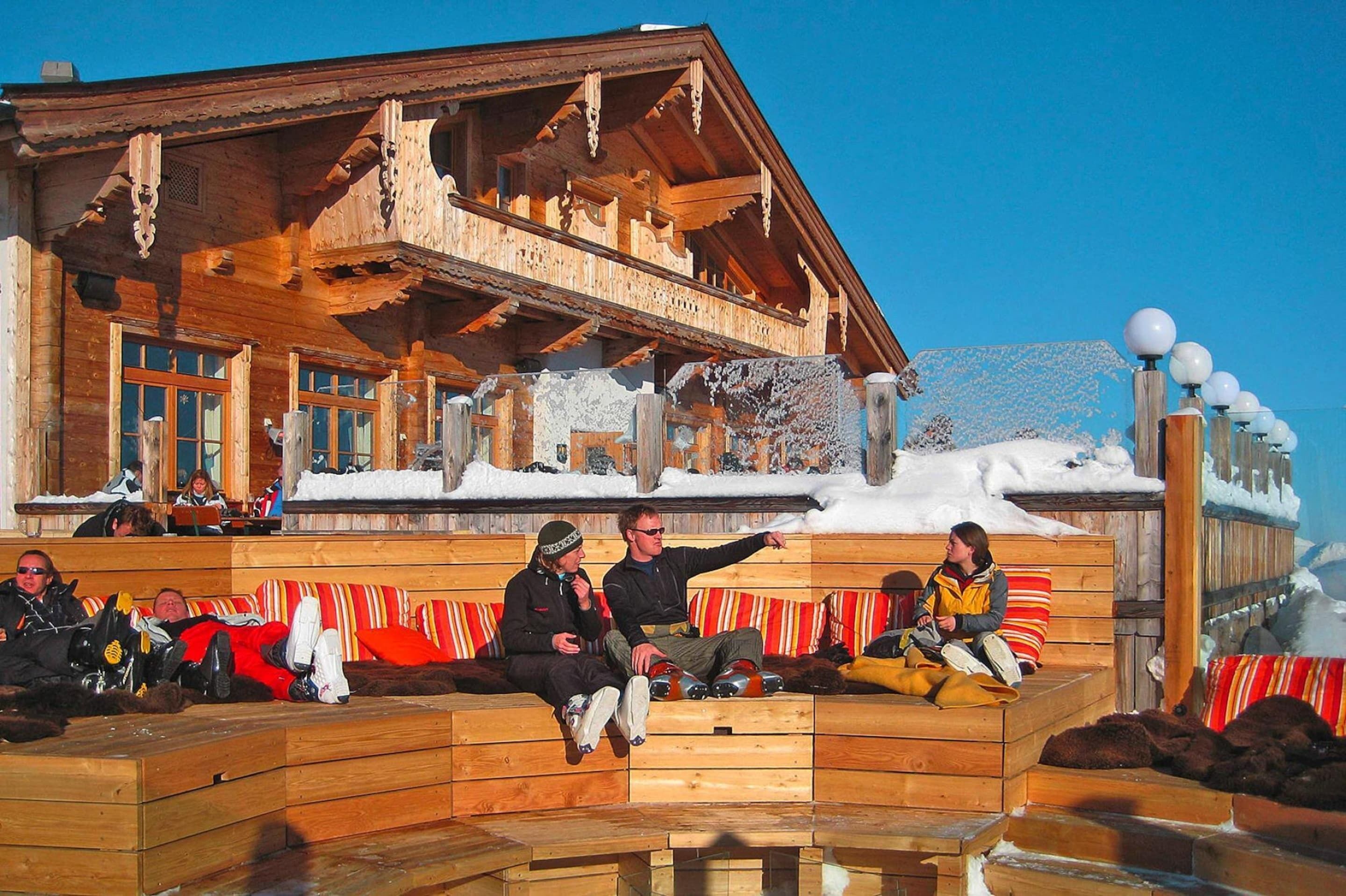 Un chalet in legno con un balcone e un tetto imbiancato dalla neve.