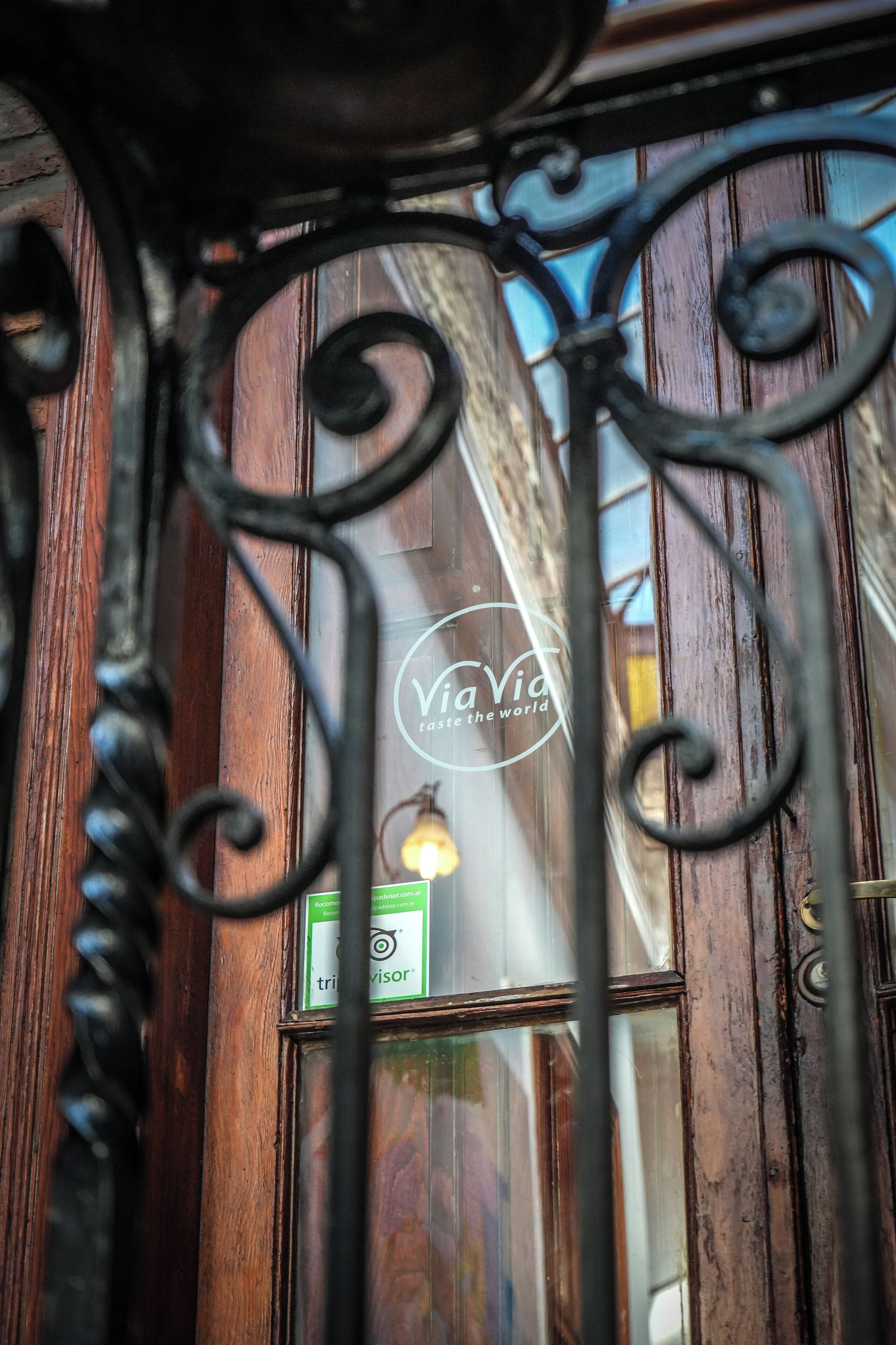 Una puerta de madera con un letrero que dice "ViaVia Taste the World".
