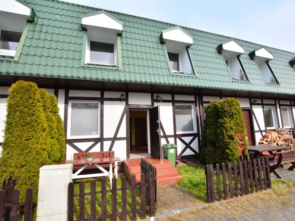 A traditional building with a green roof, multiple windows, and a wooden fence. - Comfy Holiday Home for 5 People in Plesna (gmina Bedzino)