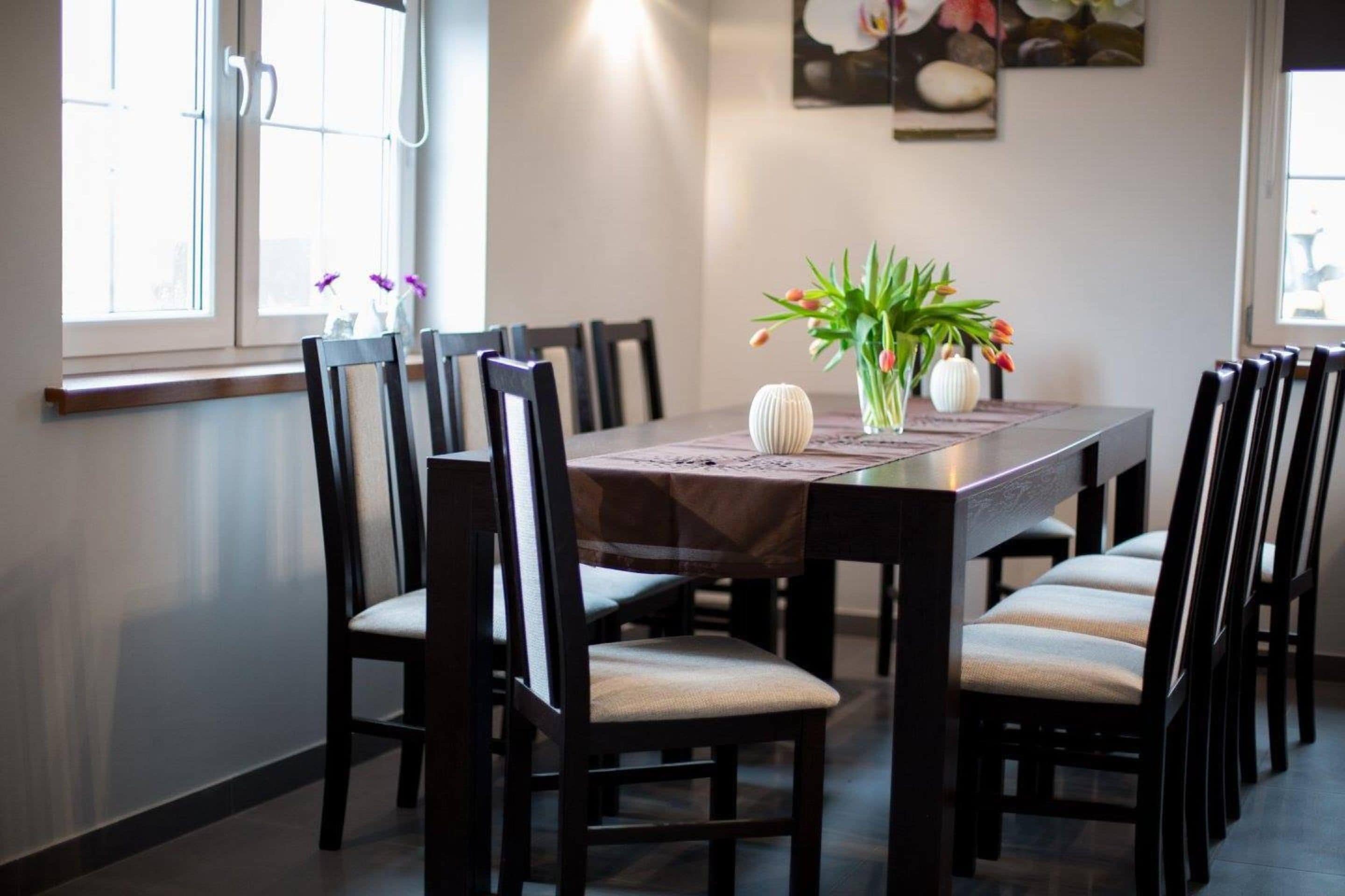 Een eethoek met een rechthoekige tafel omringd door stoelen met zachte zitkussens.